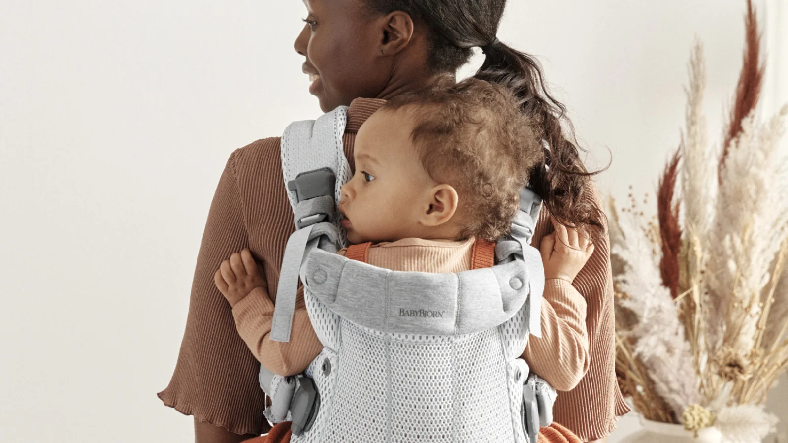 Parent portant un bébé pour comparer les meilleurs porte-bébés